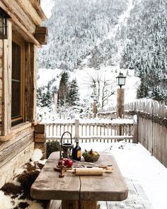 a wooden table sitting on top of a snow covered ground