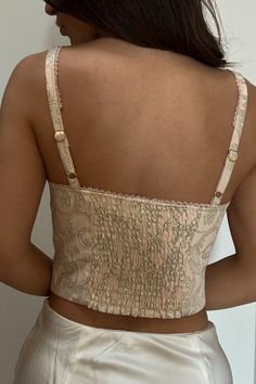 Shine on in this Renaissance-inspired corset top fit for a lady with a pink metallic jacquard finish. Oh, and that lace-up front? To die for. / Lurex jacquard fabric 62% Polyester, 34% Rayon, 4% Lurex Fully linedMicro lace trim at neckline and strapsLace up front detail with metal D ringsUnderwire and boning for supportSmocking at back panel for stretchAdjustable straps Party Lace Top With Corset Back, Party Tops With Lace Trim And Underbust Shape, Party Lace Tops With Boned Bodice, Pink Lace Crop Top For Party, Lace Tops With Corset Back, Pink Metallic, Shine On, A Lady, Jacquard Fabric