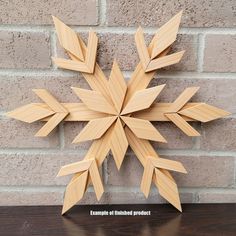 a wooden snowflake sitting on top of a table next to a brick wall