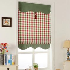 a window with a red and green checkered valance next to a white chair