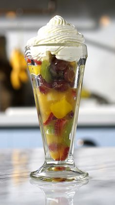 a glass cup filled with fruit and whipped cream