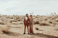 a man and woman standing in the desert