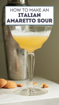 a glass filled with orange juice next to cookies