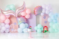 a little mermaid themed birthday party with balloons, cake and balloon decorations on the table