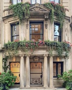 an old building with many windows and plants growing on the front door, along with two large pillars