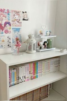 a white shelf with books and figurines on it