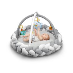 a baby laying on top of a white blanket in a play gym with toys around it