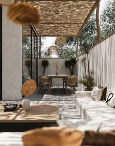 an outdoor living area with white couches and wooden tables