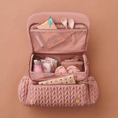 an open pink suitcase with various items inside