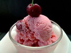 an ice cream sundae with cherries on top and a man's face next to it