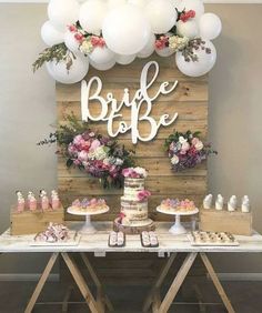 a table topped with cake and balloons next to a wooden sign that says bridal