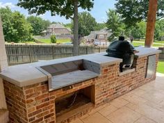 an outdoor bbq grill built into the side of a brick wall with a large grill on it