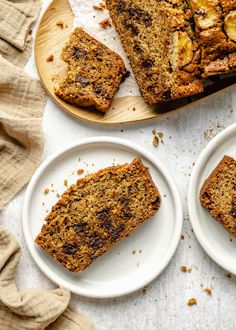 three plates with slices of banana bread on them next to a loaf of banana bread