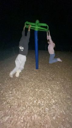 two children playing on a playground at night