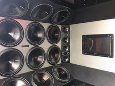 there are many speakers on the wall next to each other in front of a speaker system