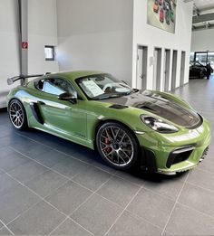 a green sports car parked in a showroom