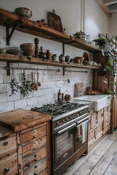 an old fashioned kitchen with wooden cabinets and white tile backsplash, wood flooring