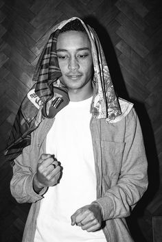 black and white photograph of a young man wearing a hoodie holding something in his hand