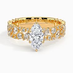 a yellow gold engagement ring set with a pear shaped diamond in the center and side stones