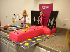 two barbie dolls are on top of a cake