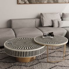 two tables sitting on top of a rug in front of a couch