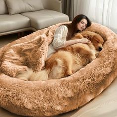 a woman laying on top of a dog bed