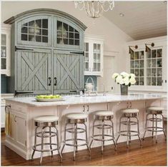 a large kitchen with an island in the middle and lots of stools around it