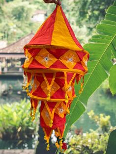 a red and yellow kite hanging from a tree