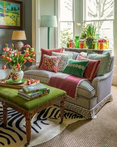 a living room filled with lots of furniture and colorful pillows on top of it's covers