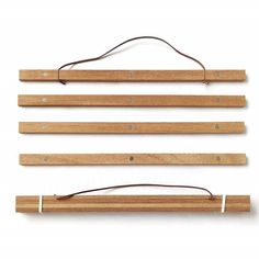 three pieces of wood hanging on a wall with wires attached to it and two different lengths of wooden hangers