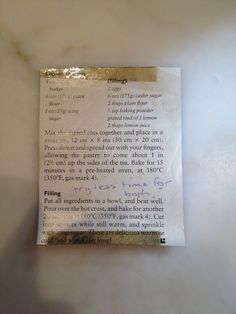 a piece of paper with writing on it sitting on top of a white countertop