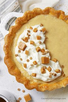 a pie topped with whipped cream and caramel pieces