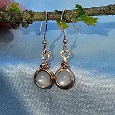 **Made-to-order** Moonstone cabochons wire wrapped from 14k rose gold-filled wire into a perfectly simple and versatile pair of dainty earrings, hanging delicately from 14k rose gold-filled ear hooks. Add a touch of elegance to any outfit with these stunning handmade dangle earrings. Their simple design and vintage boho charm make them a perfect choice for any occasion. Versatile and classy, these earrings are a must-have accessory for any jewelry collection. Beyond their beauty, these earrings Dainty Wire Wrapped Round Earrings, Elegant Hand Wrapped Drop Earrings, Elegant Hand Wrapped Moonstone Jewelry, Delicate Wire Wrapped Round Earrings, Unique Dangle Moonstone Jewelry, Elegant Hand-wrapped Moonstone Jewelry, Delicate Moonstone Dangle Jewelry, Dainty Moonstone Gemstone Earrings, White Moonstone Wire Wrapped Earrings