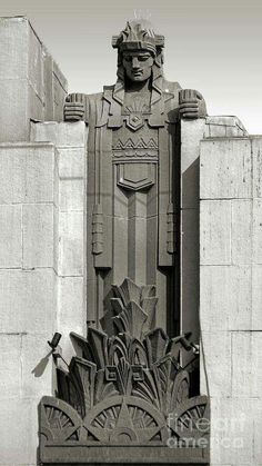 a black and white photo of a statue in front of a building