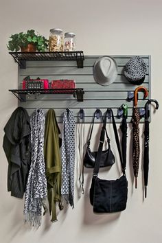 a coat rack with umbrellas, hats and other items hanging on it's sides