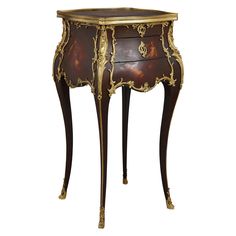 an ornately decorated side table with drawers