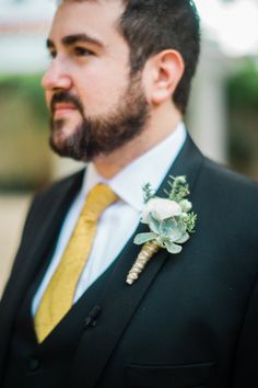 a man in a suit with a boutonniere on his lapel