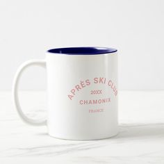 two white and blue coffee mugs sitting on top of a marble countertop with the words apres ski club