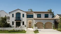 a large white house with two garages on each side