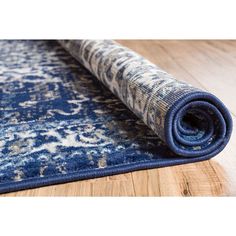 a blue and white rug on the floor with a wood flooring area behind it