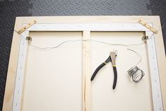 a pair of pliers and wire hang on a wall