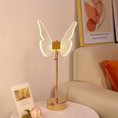 a white butterfly lamp on a table next to a card