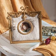 an old photo frame with a woman's face in it on top of a table