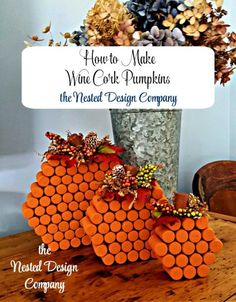 an orange vase filled with flowers on top of a wooden table next to a sign that says how to make wine cork pumpkins the neat design company