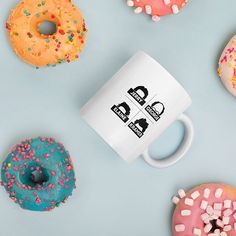 a coffee mug surrounded by donuts and sprinkles on a blue background