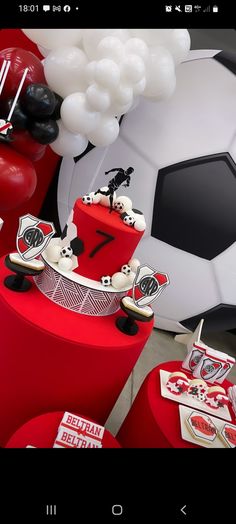 a soccer themed birthday party with balloons, cake and decorations in red and white colors