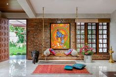 a living room filled with lots of furniture next to an open window covered in art