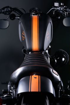 an orange and black motorcycle is parked in the dark