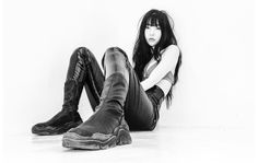 a black and white photo of a woman sitting on the floor with her legs crossed