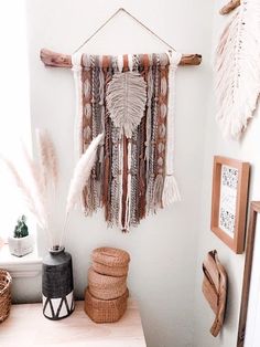 a wall hanging with feathers on it next to a potted plant and other items